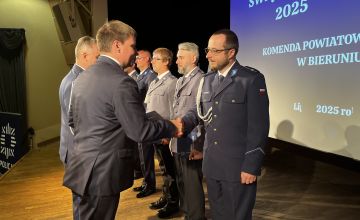 Mężczyzna gratulujący na scenie policjantom
